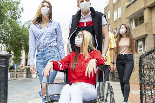 Männer und Frauen mit behinderten Freundinnen mit Masken in der Stadt — Stockfoto