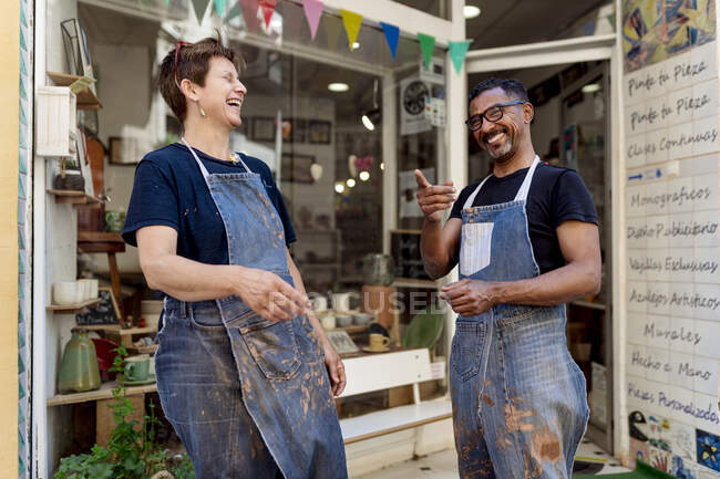 Collaboratori allegri parlare mentre in piedi fuori negozio di ceramica — Foto stock