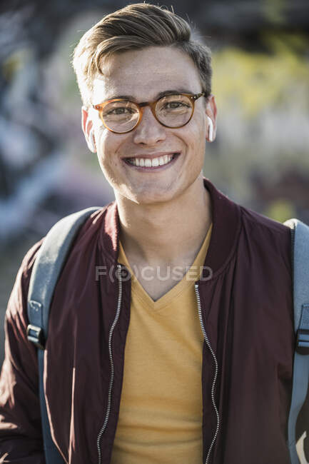 Улыбающийся красивый молодой человек в очках — стоковое фото