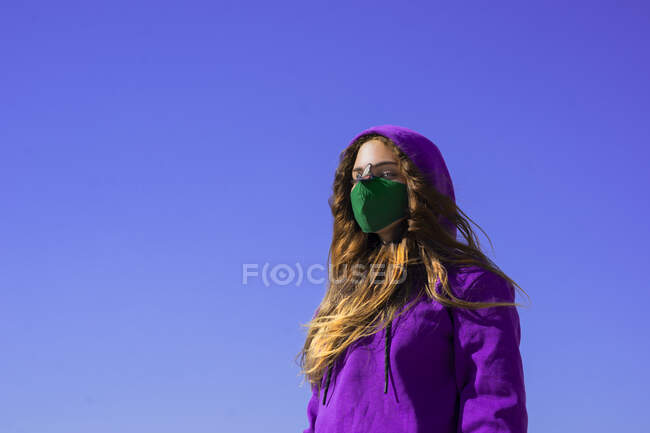 Ragazza adolescente indossa felpa con cappuccio e maschera protettiva con adesivo mosca sul naso — Foto stock