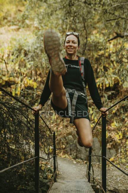 Mulher sorridente balançando no corrimão da ponte em Sierra De Hornachuelos, Córdoba, Espanha — Fotografia de Stock