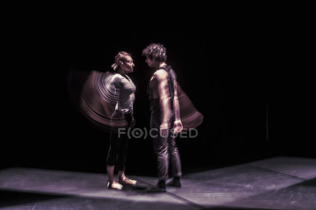 Lunga esposizione di ballerini che si esibiscono sul palco nero, in piedi faccia a faccia — Foto stock