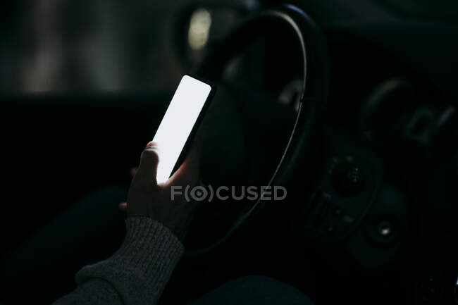Man using mobile phone while sitting in car at night — Stock Photo
