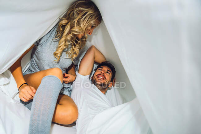 Feliz joven pareja hablando en la cama en casa — Ocio, Fin de semana -  Stock Photo | #479930326