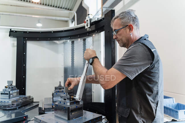 Expertise repairing manufacturing equipment while standing at industry — Stock Photo