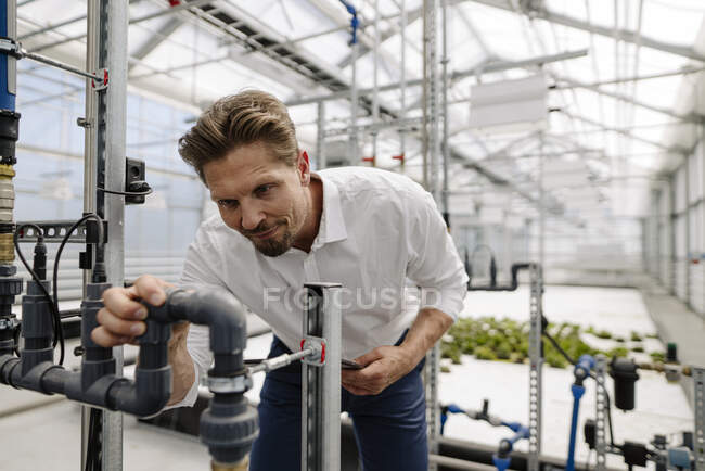 Apparecchiature di irrigazione per esami professionali maschili in serra — Foto stock