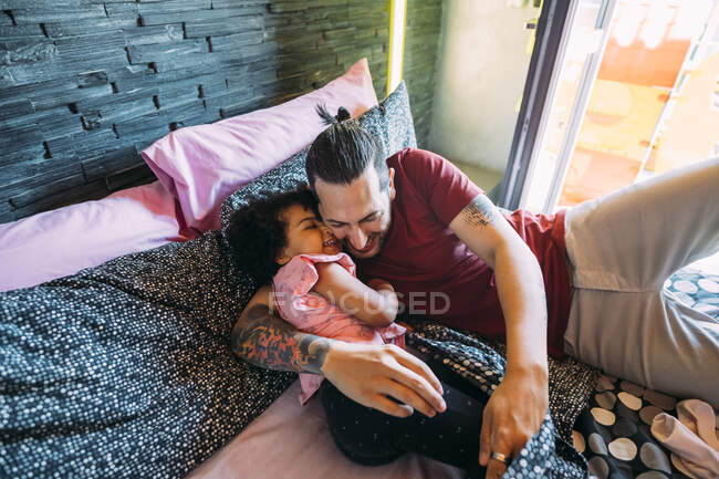 Грайливий батько і дочка лежали на ліжку. — стокове фото