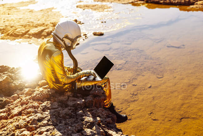 Astronauta trabajando en el portátil mientras está en la luna - foto de stock