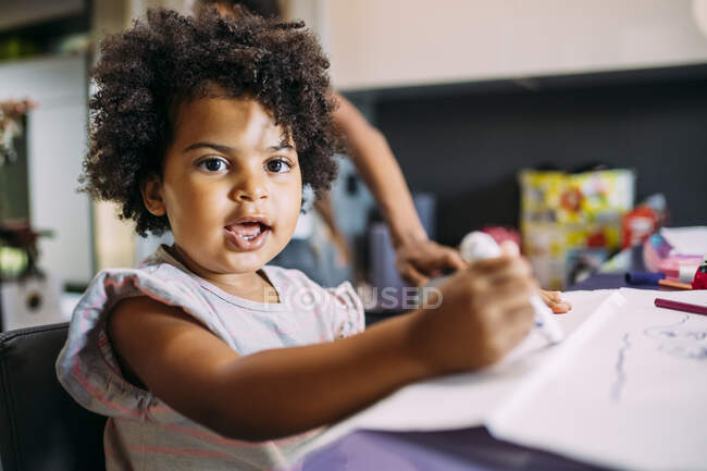 Close-up of cute baby girl drawing on paper at home — Stock Photo