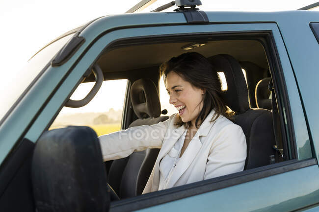 Весела молода жінка за кермом під час подорожі. — стокове фото