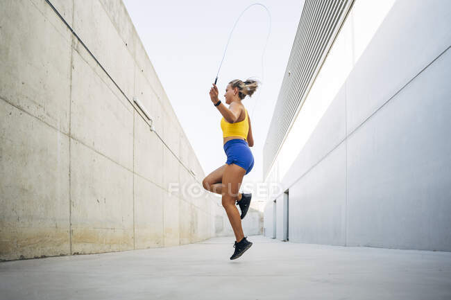 Jeune femme sauter corde — Photo de stock