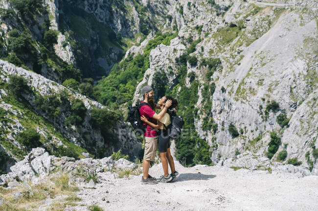 Giovane uomo che abbraccia una donna in piedi sulla montagna a Ruta Del Cares, Asturie, Spagna — Foto stock