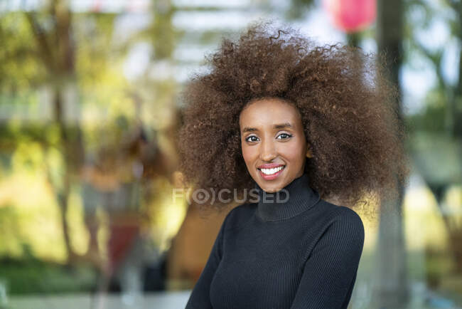 Nahaufnahme Porträt einer lächelnden Geschäftsfrau mit lockigem Kraushaar im Freien — Stockfoto