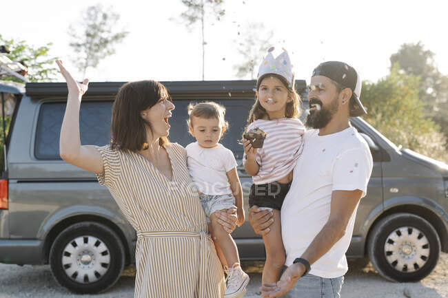 Cheerful family enjoying sunset against van at park — Stock Photo