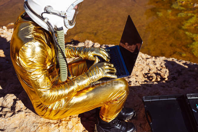 Astronauta usando laptop enquanto está sentado na lua — Fotografia de Stock