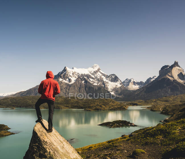 Uomo in giacca con cappuccio in piedi sulla roccia al Lago Pehoe nel Parco Nazionale Torres Del Paine, Cile Patagonia, Sud America — Foto stock