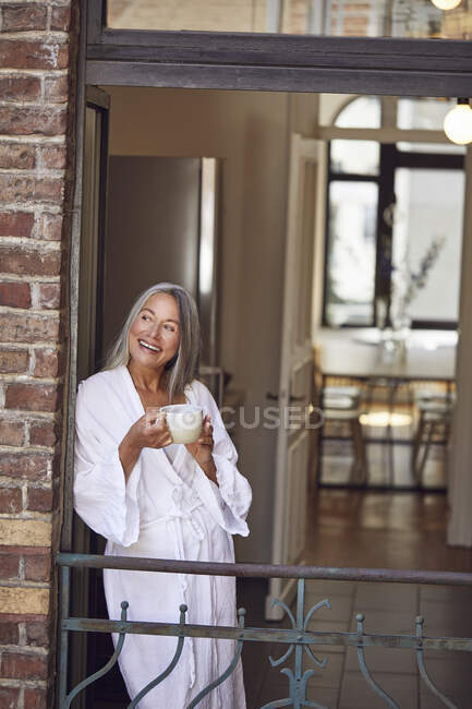 Mulher feliz bebendo chá na varanda — Fotografia de Stock