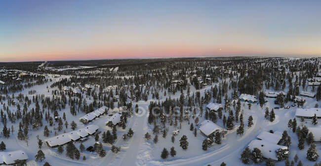 Finland, Lapland, Saariselka, Aerial view of snow-covered mountain village at dusk — Stock Photo