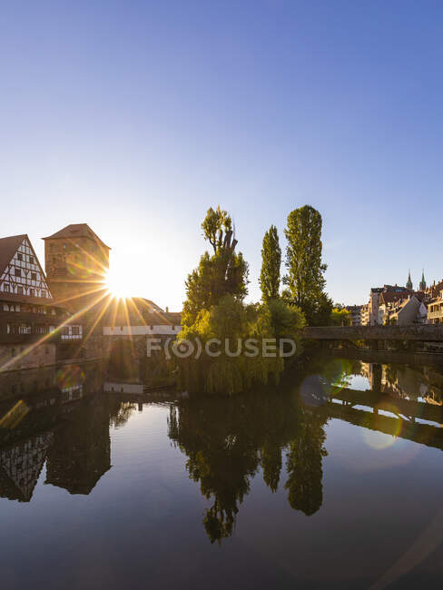 Alemania, Baviera, Núremberg, Henkersteg, Weinstadel y Wasserturm se reflejan en el río Pegnitz al atardecer - foto de stock