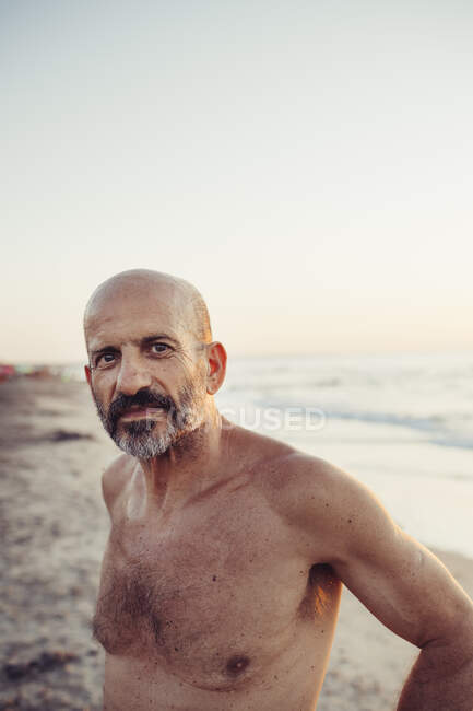 Shirtless Senior Man Standing At Beach — Italy 60s Stock Photo