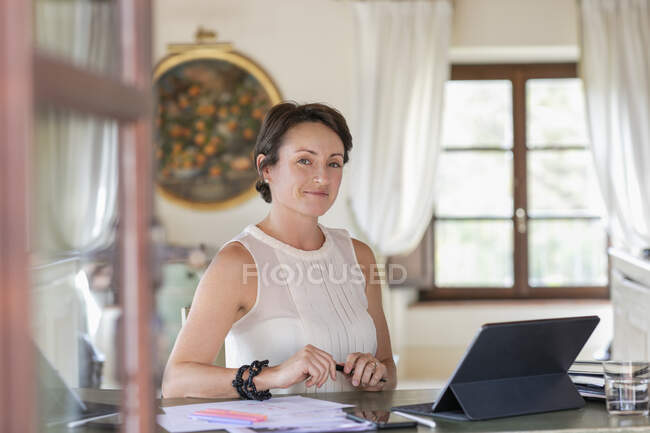 Creative female professional sitting by digital tablet in home office — Stock Photo