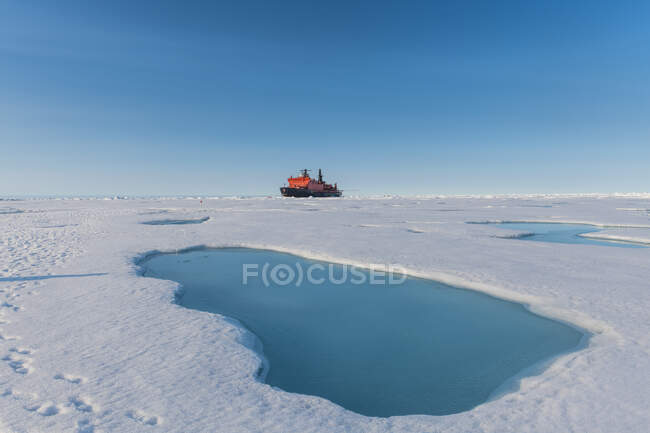 Vue aérienne de la fonte de la glace sur le pôle Nord avec un brise-glace 50 ans de victoire en arrière-plan — Photo de stock