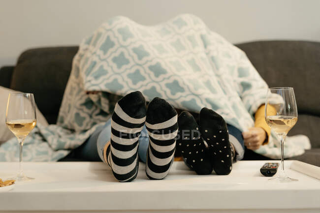 Madre e figlia si nascondono sotto una coperta sul divano — Foto stock
