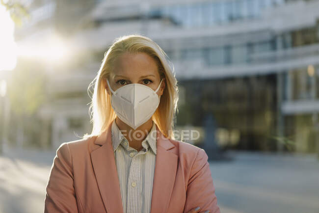 Біла жінка - професіонал, одягнена в захисну маску в фінансовому районі під час коронавірусу. — стокове фото
