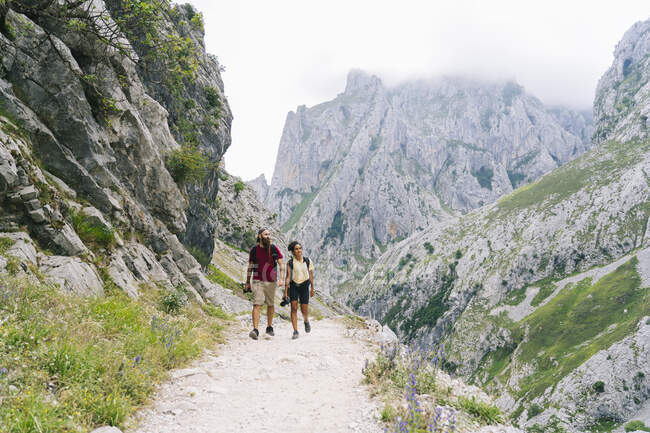 L'uomo e la donna camminano insieme sul sentiero di montagna a Ruta Del Cares, Asturie, Spagna — Foto stock