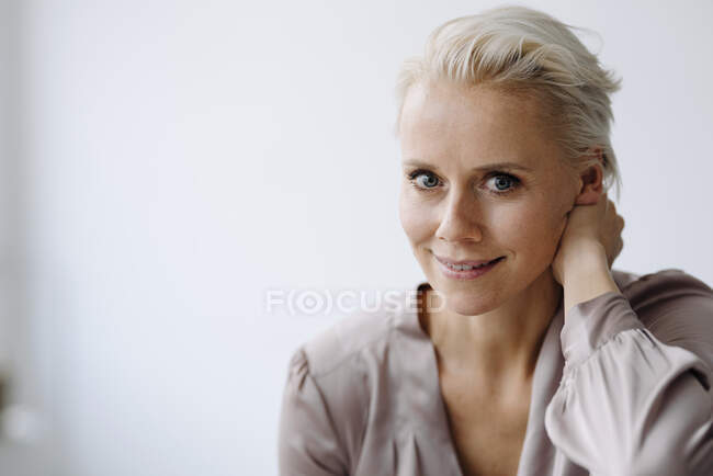 Close-up of confident businesswoman against white wall in office — Stock Photo