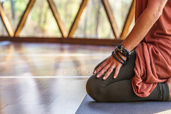 Mature woman meditating on yoga mat at health retreat — Stock Photo