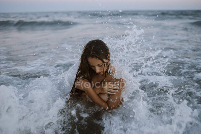 Giovane donna che fa il bagno in mare durante il tramonto — Foto stock