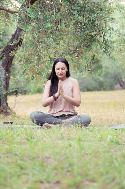 Mature woman during yoga in park — Stock Photo