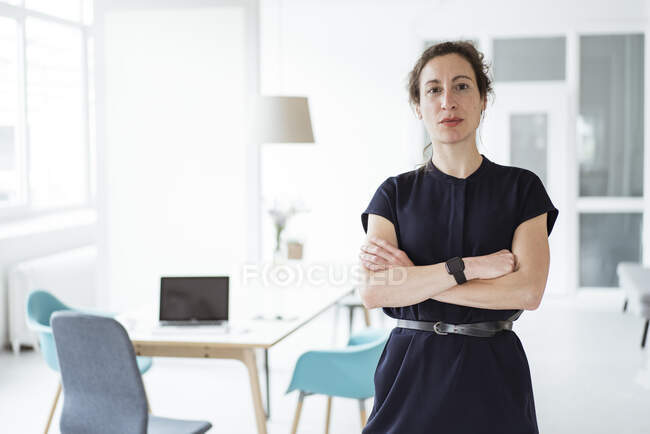 Serious female entrepreneur with arms crossed standing — Stock Photo