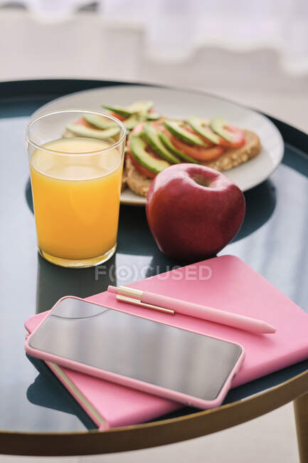 Teléfono inteligente por desayuno saludable en la mesa en casa - foto de stock