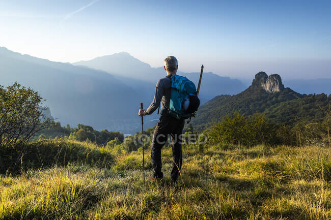 Escursionista maschio con zaino che guarda la montagna contro il cielo all'alba, Orobie, Lecco, Italia — Foto stock