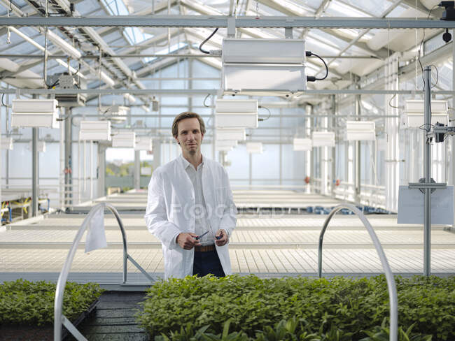 Retrato de un científico confiado en un invernadero - foto de stock