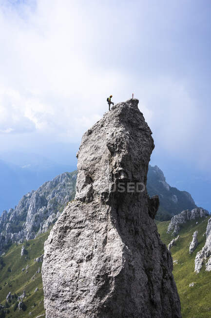 Hombre excursionista de pie en la cima de la montaña contra el cielo, Alpes europeos, Lecco, Italia - foto de stock