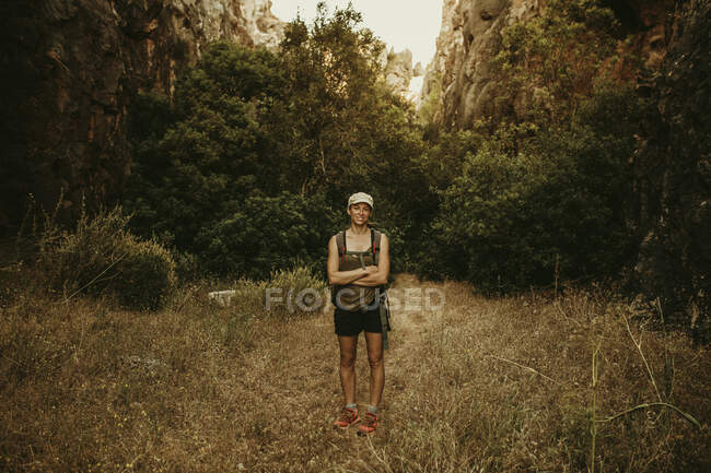 Woman trekker standing with arms crossed in forest — Stock Photo