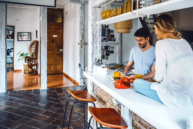 Junger Mann bereitet mit Freundin zu Hause Essen in Küche zu — Stockfoto
