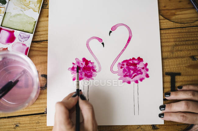 Primer plano de la mujer pintura a mano Flamingo animal sobre papel - foto de stock