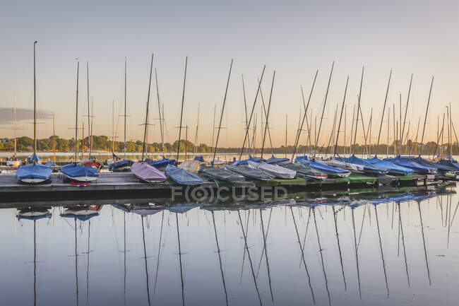 Germany, Hamburg, Row of sailboats moored on Outer Alster Lake at sunset — Stock Photo