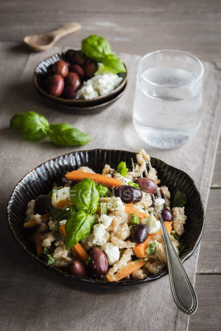Bol de spaetzle végétarien aux carottes, olives, fromage feta et basilic — Photo de stock