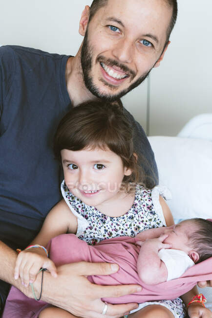 Padre e figlia che tengono la neonata sul letto in ospedale — Foto stock