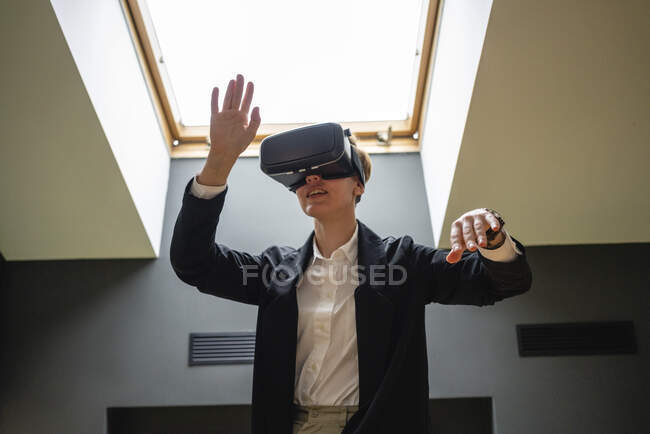 Businesswoman gesturing while wearing virtual reality simulator headset at office — Stock Photo