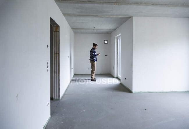 Construction worker standing in empty house at construction site — Stock Photo