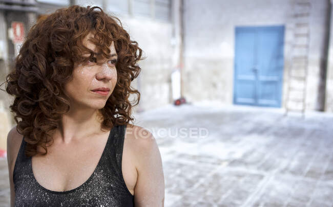 Redhead woman with white dust stains on face looking away — Foto stock