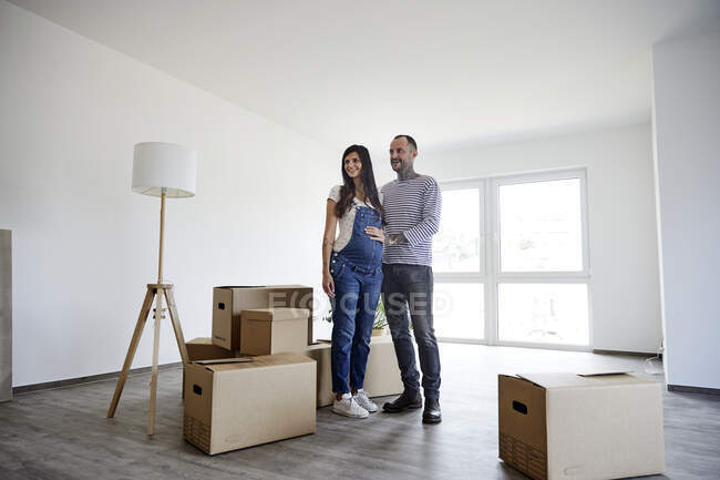 Couple standing on floor with cardboard boxes — Stock Photo