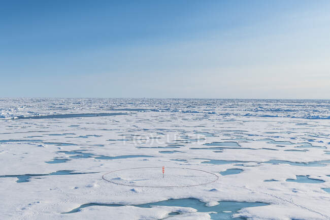 Вид с воздуха на круглый маркер, установленный на тающем льду на Северном полюсе — стоковое фото