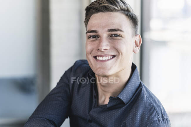 Close-up of smiling handsome professional sitting in office — Foto stock